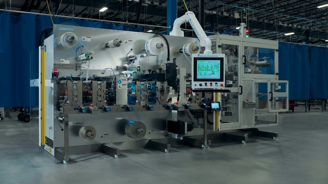 Automated packaging machine with touch screen and robotic arm.