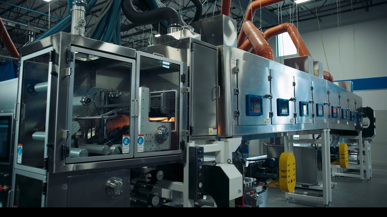 Industrial machine with stainless steel casing, glass doors, and multiple viewing windows.
